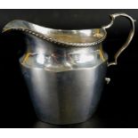 A George V silver milk jug, of fluted form, with reeded border, an acanthus leaf handle,