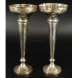 A pair of Edwardian silver stem vases, with pierced circular tops, on fluted stems, weighted base,