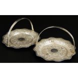 A pair of Eastern white metal dishes, decorated with palm trees and buildings, with swing handle,