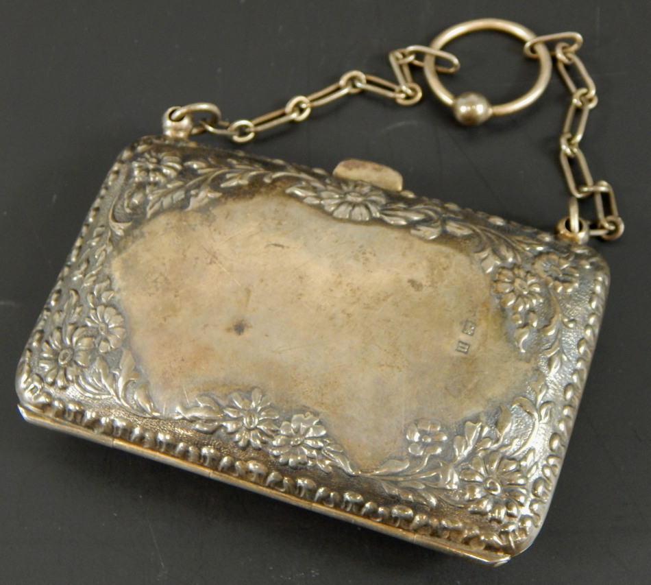 A George V silver coin purse, with foliate design, and leather interior, 2½oz. (M)