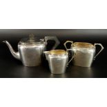 An Edwardian silver three piece tea set, comprising teapot, 13cm high, milk jug, 7cm high, and sugar