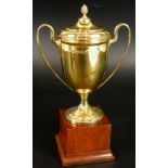 A George VI silver gilt trophy and stand, the two handled trophy with lid, on mahogany base,