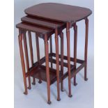 A nest of three Edwardian mahogany tables, each with a shaped top on turned legs and square feet,