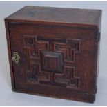 A late 17th/early 18thC oak table cabinet, with a single raised panelled door, enclosing an