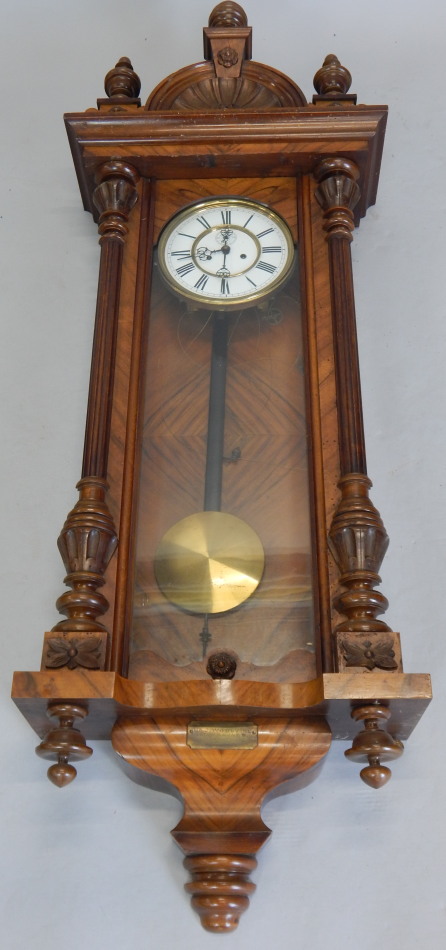 A late 19th/early 20thC Vienna walnut wall clock, with enamel type dial, shaped crest, bearing