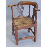 A George III walnut corner chair, with a shaped back above two pierced splats and a drop in woven