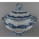 A 19thC opaque and porcelain blue printed tureen, the lid with a dolphin finial, the base with