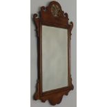 An oak fret frame wall mirror, in George III style, the shaped crest with a pierced parcel gilt