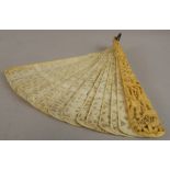 A fine 19thC Chinese ivory fan, the end sticks having relief carved Canton scenes of figures in