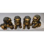 A set of four oriental style gilt painted metal dogs of fo, each with bronzed embellishment to the