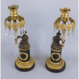 A pair of Regency bronze and gilt metal candlesticks, each cast in the form of a seated Oriental