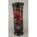 An early 20thC Moorcroft vase, decorated with a design of flowers and leaves on a mottled green