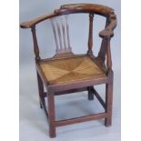 A George III mahogany corner chair, with a shaped back, two pierced splats and a drop in woven