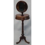 A Victorian mahogany shaving stand, with a circular adjustable mirror above a platform with two