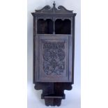 A late 19thC carved oak corner cabinet, with a shaped cornice above a recess, the door enclosing a