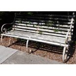 A late 19thC railway or park type bench, with three wrought iron supports and white painted