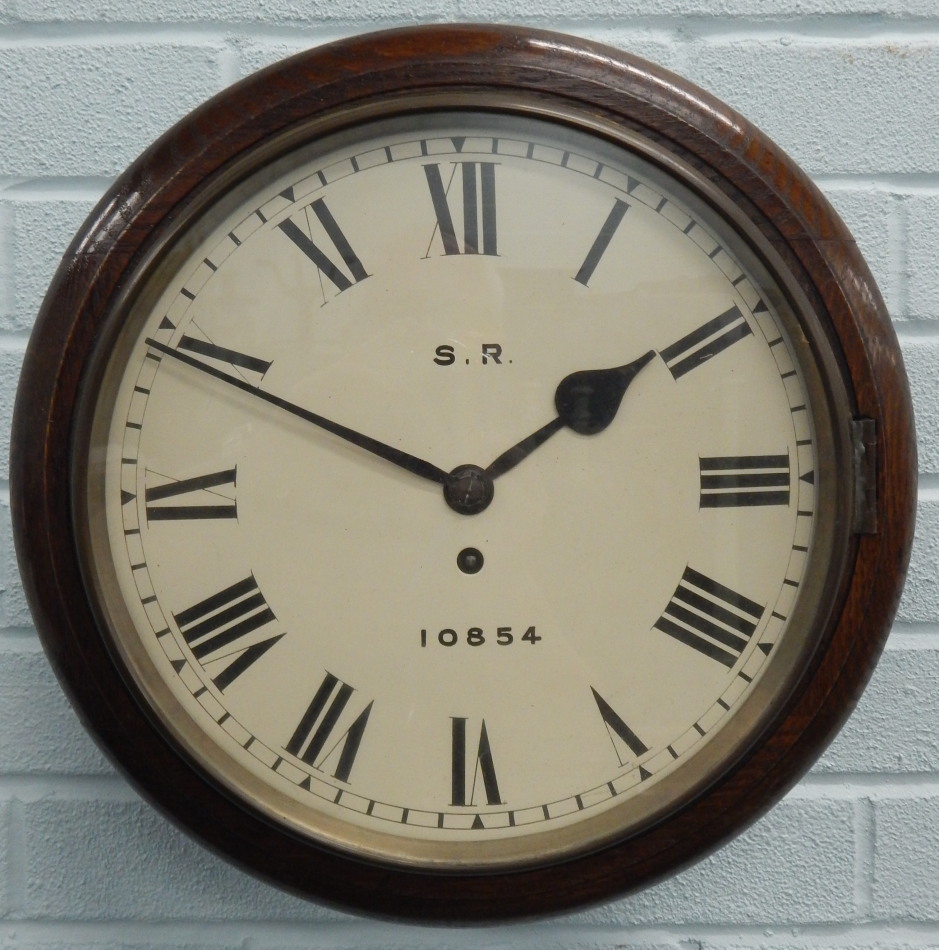 A late 19th/early 20thC oak railway wall clock, the white enamel dial signed S.R., 10854, with brass