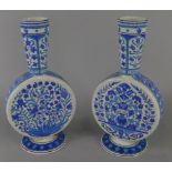 A pair of Minton Iznik style pottery moon flasks, each decorated with flowers in turquoise and blue,