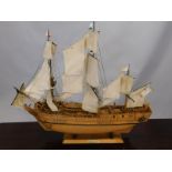 A scale model of HMS Bounty, with three sails, flying the blue ensign, 87cm long