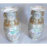 A large pair of late Chinese porcelain vases, each with Canton style decoration and with gilt