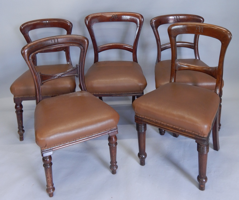 A set of five Victorian mahogany railway related dining chairs, each with a brown leatherette padded