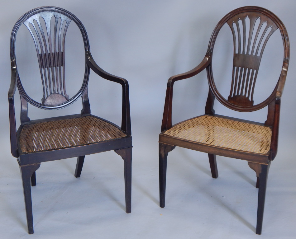 A near pair of late 19th/early 20thC open armchairs, each with a pierced splat and a cane seat, on