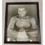 A black and white photograph of Muhammad Ali, bearing signature, in glazed frame, 25cm x 21cm (M)