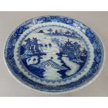 A late 19thC Chinese export saucer dish, decorated in blue with figures on a bridge, within a