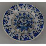 A Continental faience plate, decorated with birds in blue, on a cream ground, unmarked (M)