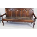 An early 18th/late 17thC oak settle, with a panelled back, shaped arms and planked seat on