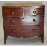 An early 19thC mahogany bow fronted chest of drawers, with plain top, above two short and two long