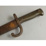 A 19thC 1872 model bayonet and scabbard, with shaped partially engraved blade, turned handle and