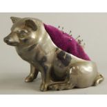 A Victorian silvered metal pin cushion, modelled in the form of a seated pig, 8cm high