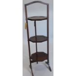 A Edwardian mahogany three tier adjustable cake stand, on splayed legs.