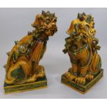 A pair of large oriental style temple dragons, each with mottled brown, green with black glaze,