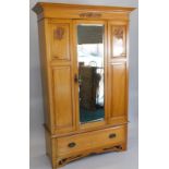 A late Victorian satin walnut wardrobe, with single bevelled plate to the door, above a drawer