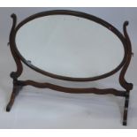 A mahogany dressing table mirror, the oval plate on shaped supports, 71cm wide.