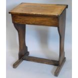 An early 20thC oak child's school desk, with slope hinged top, on shaped end supports, 66cm wide.