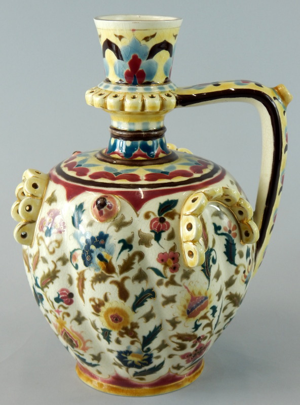 A late 19thC Zsolnay Pecs ceramic ewer, decorated with Islamic style flowers, leaves etc., in