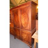 An early 19thC mahogany wardrobe, the top with a moulded cornice, above two panelled doors,