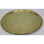 An Eastern circular brass tray, engraved with script, leaves, etc., 57cm dia.