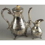 An early 20thC silver plated coffee pot and jug, each heavily embossed, with a bulbous shaped