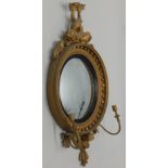 A Regency giltwood and gesso convex girandole, with an intertwined dolphin crest, a reeded slip