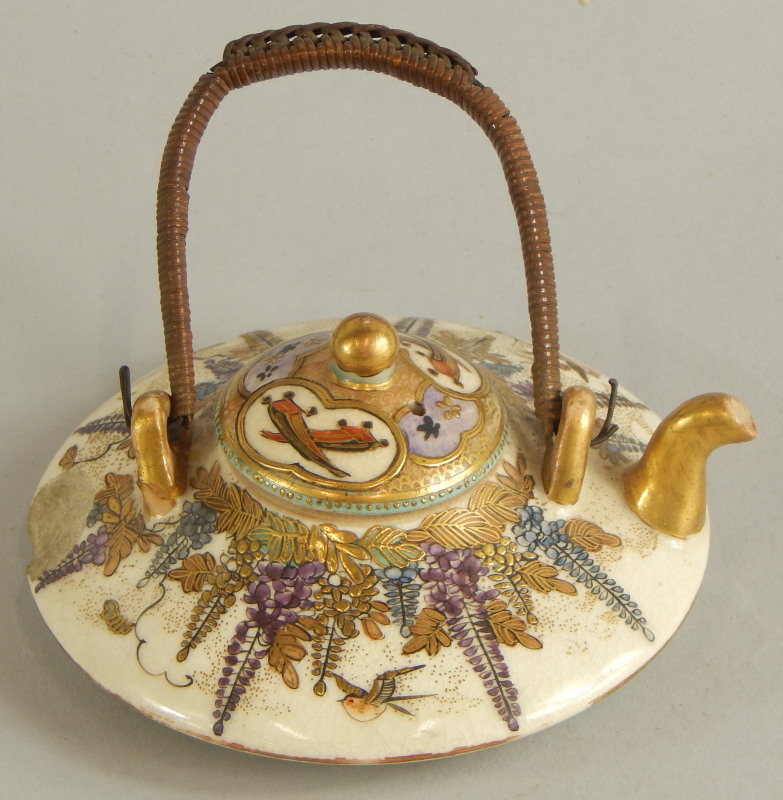 A small satsuma miniature teapot, decorated with figures, flowers etc., marked to the underside (