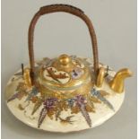 A small satsuma miniature teapot, decorated with figures, flowers etc., marked to the underside (