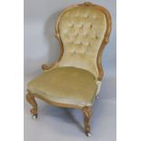 A Victorian walnut spoon back nursing chair, with a button back, padded seat on cabriole legs with