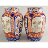 A pair of Japanese Imari porcelain vases, each decorated with trees, flowers, etc., in typical