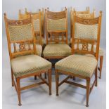 A set of eight Victorian oak dining chairs, in Art Nouveau style, each with a padded back and seat