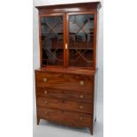 A Regency mahogany and ebony strung secretaire bookcase, the top with a moulded cornice above two