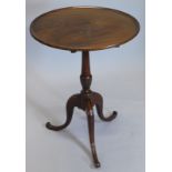 A George III mahogany tilt top table, with a circular dished top, turned leaf carved column and